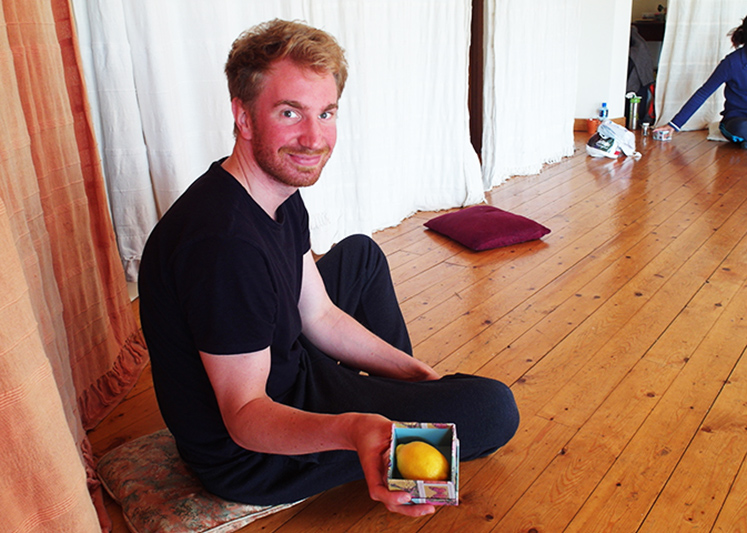 Tschechow-Training: Lächelnder mann zeigt kleine Box mit Zitrone - Arbeit an psychologischer Geste